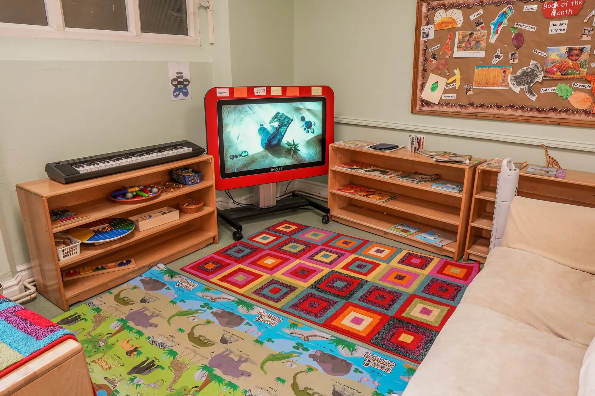 A keyboard, puzzles and an interactive screen beside colourful rugs