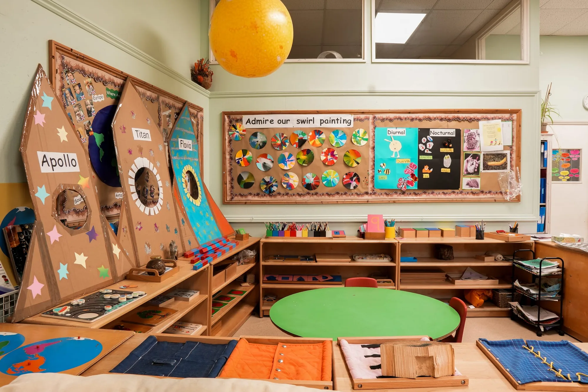 Montessori dressing frames laid out on a table in front of the rocket display