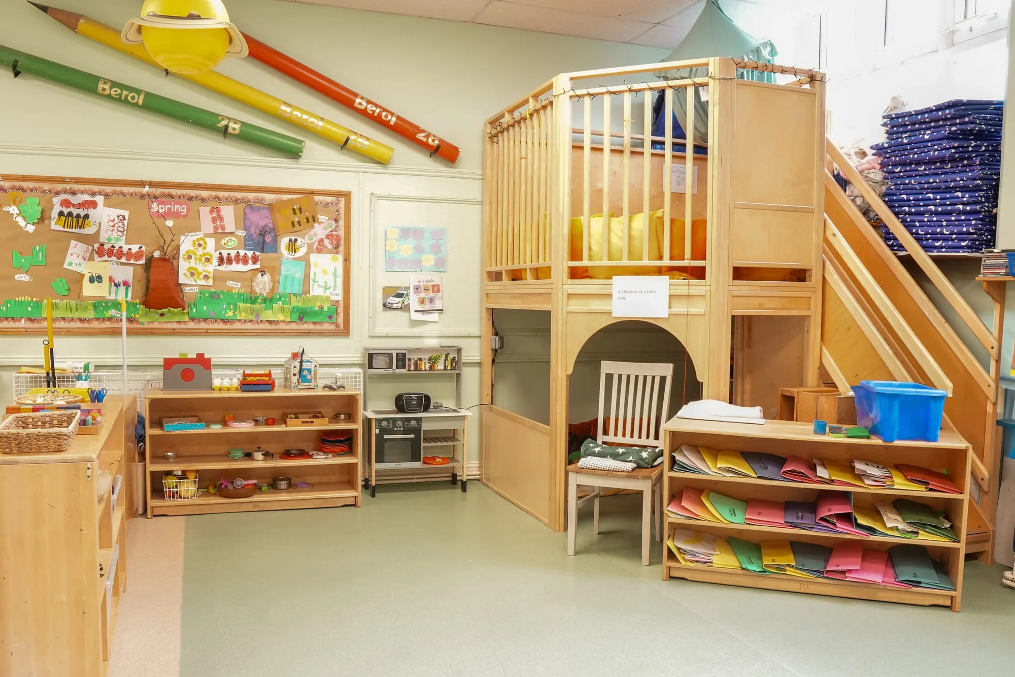 A wooden reading loft with cushions and a staircase in the Angel classroom